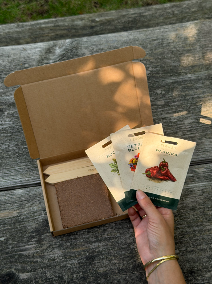 Open Grow Club-pakketje op een houten tafel met drie Feggies-zakjes, kokostablet en steeketiketten